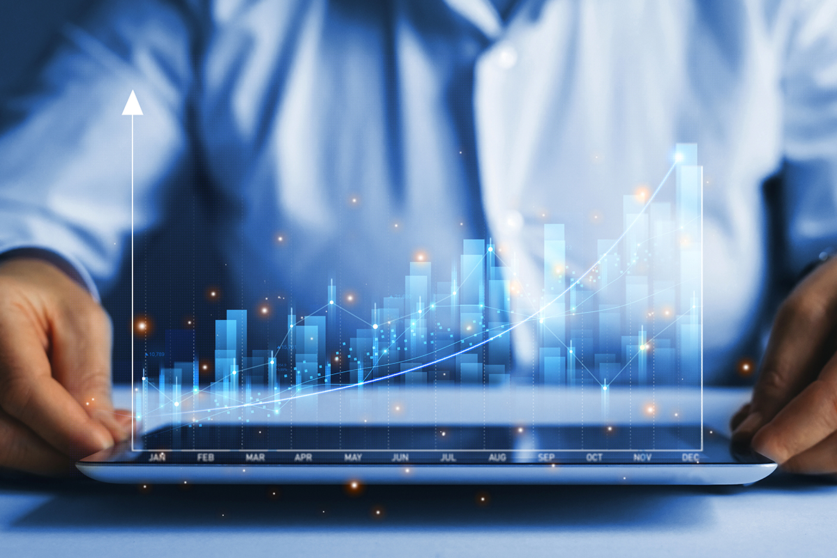 Pessoa usando tablet com gráficos financeiros em crescimento, representando o impacto do crédito privado no PIB brasileiro.